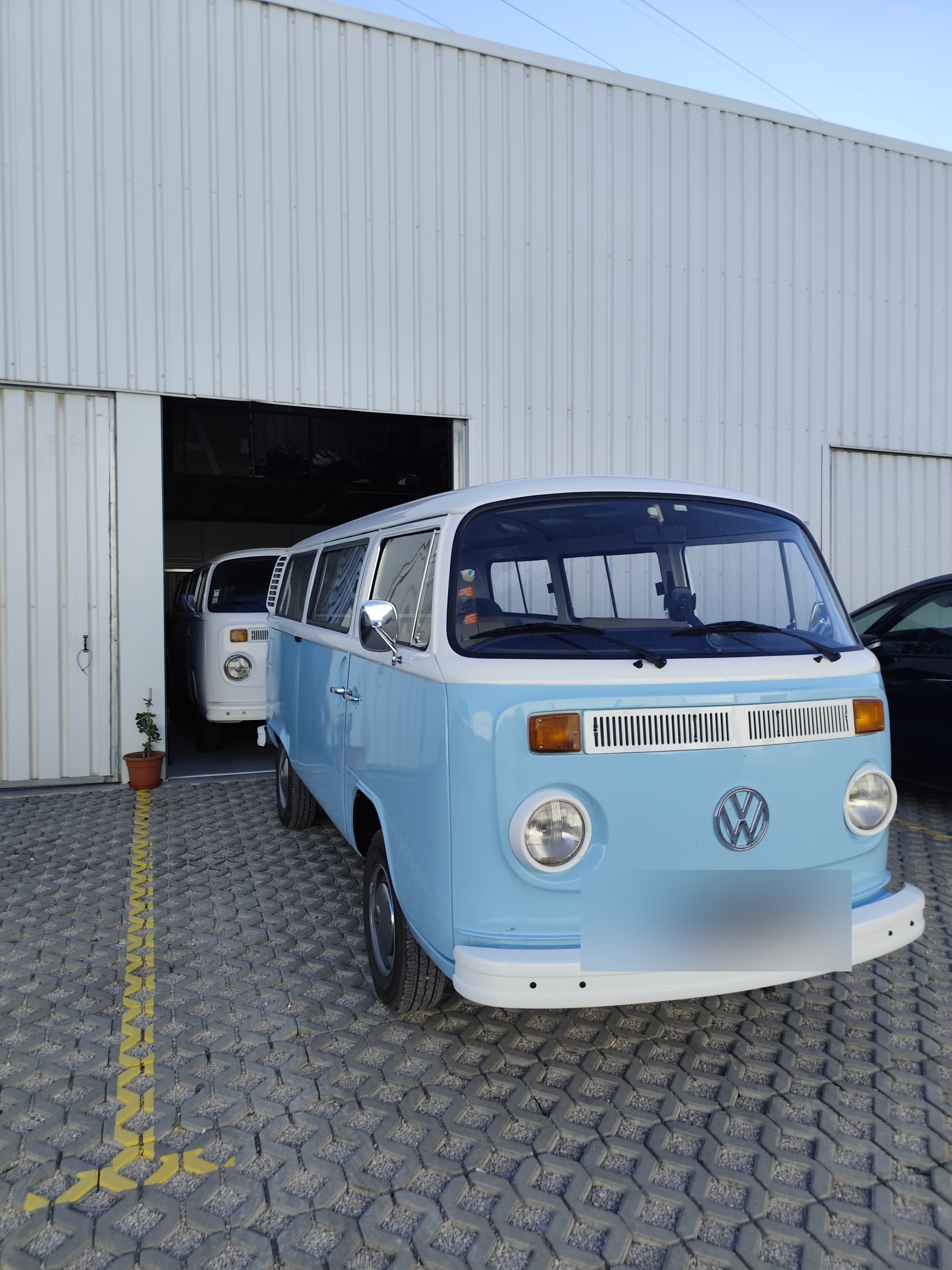 A van azul fora e a branca dentro da garagem